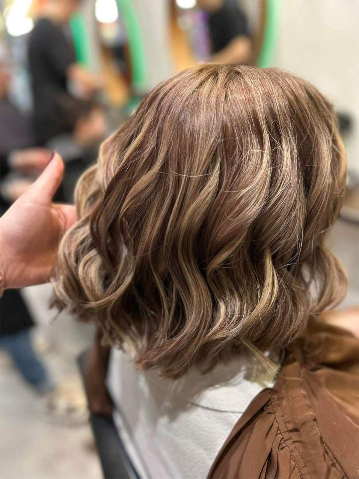 Cheveux mi-longs ondulés avec un balayage blond et caramel, Mulhouse